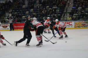 Photo of Roughriders forward, #8 Michael Posma, skating into an opposing player during college night Jan 31.